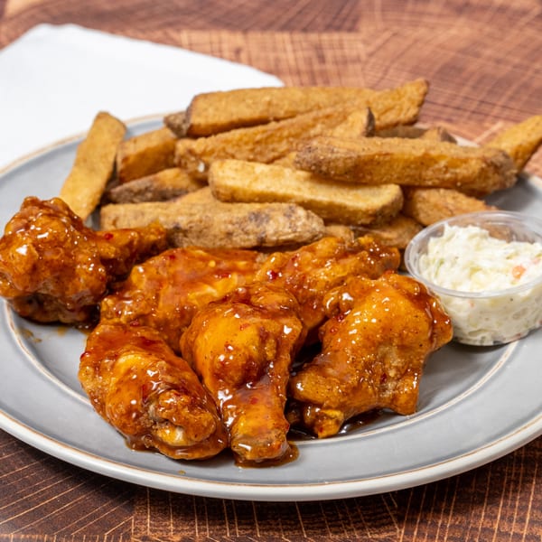Chick N' Friends fried chicken wings with sweet chili sauce, potato wedges, and coleslaw.